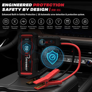 Rooboost RB-X1 portable jump starter battery clip device, shown with red and black jumper cables on a car dashboard.